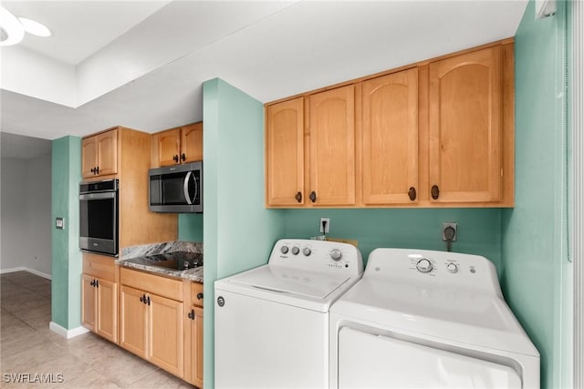 washroom with baseboards, light tile patterned flooring, and washer and clothes dryer