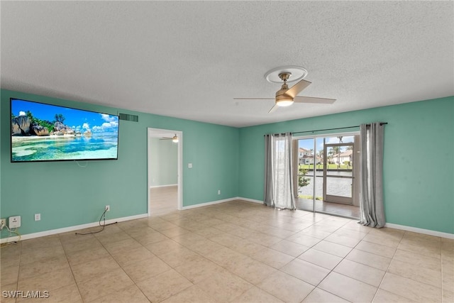 empty room featuring a textured ceiling, visible vents, baseboards, and ceiling fan
