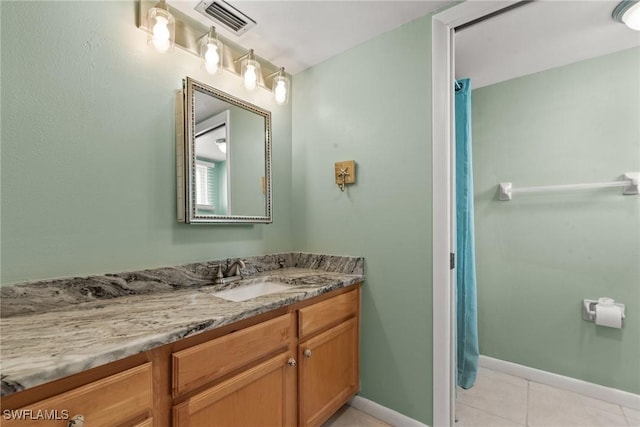 bathroom with baseboards, vanity, tile patterned floors, and visible vents