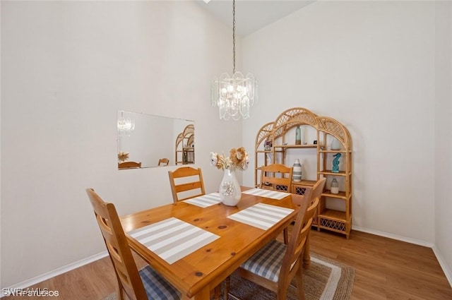 20902 Blacksmith Frg, Estero, FL 33928 - dining area with a chandelier, wood finished floors, baseboards, and a high ceiling
