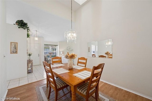 20902 Blacksmith Frg, Estero, FL 33928 - dining area featuring light wood-style floors, a chandelier, baseboards, and a towering ceiling