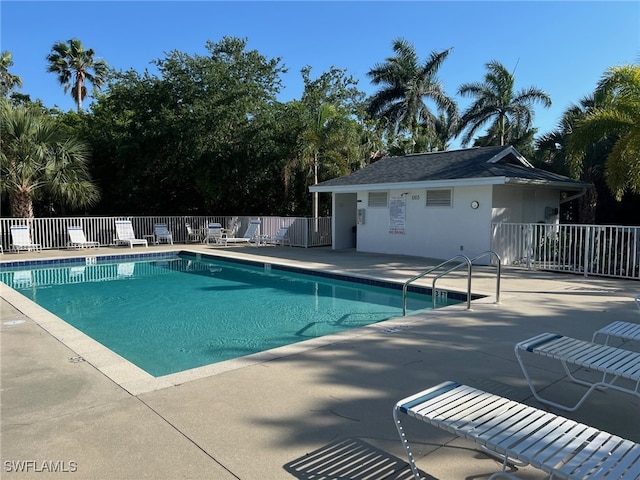 community pool with a patio area and fence