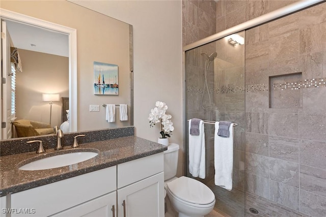 bathroom featuring toilet, a stall shower, and vanity