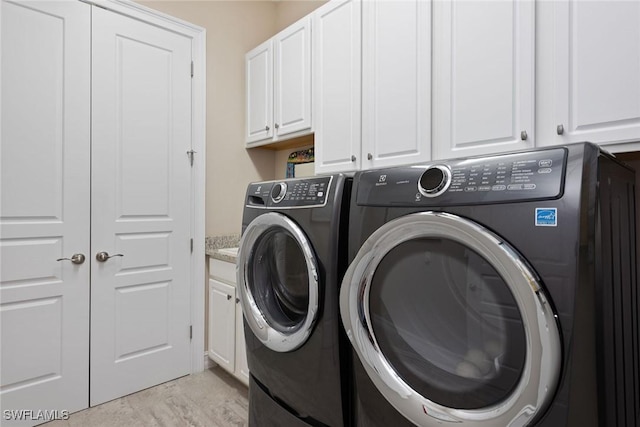 washroom with separate washer and dryer and cabinet space