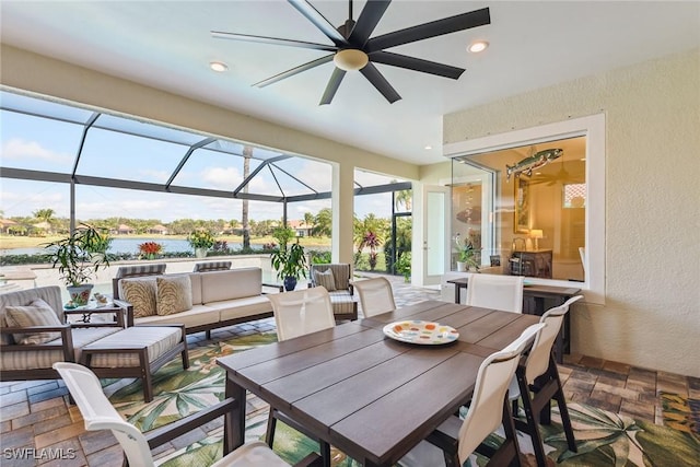 view of patio with a water view, outdoor lounge area, glass enclosure, and ceiling fan