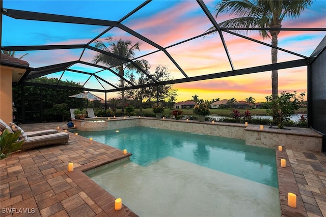 view of pool featuring a pool with connected hot tub, a patio, and a lanai