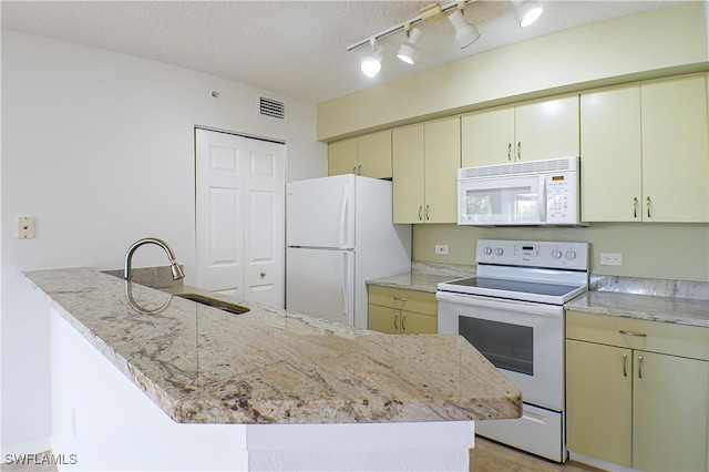 kitchen featuring white appliances, a textured ceiling, cream cabinets, visible vents, and a sink