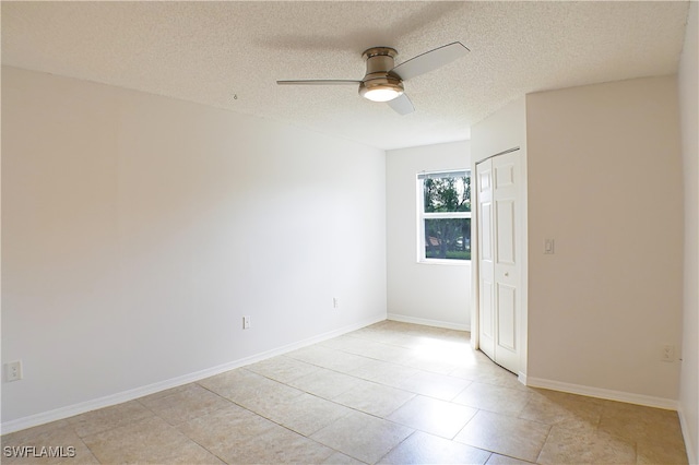 unfurnished room with a textured ceiling, baseboards, and a ceiling fan