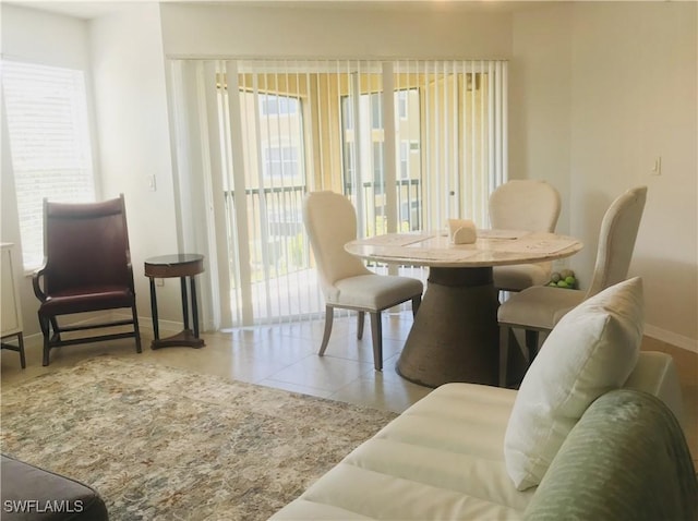 tiled dining area featuring baseboards
