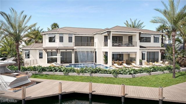 983 Sundrop Ct, Marco Island, FL 34104 - back of house with a balcony, stucco siding, metal roof, an outdoor pool, and a standing seam roof