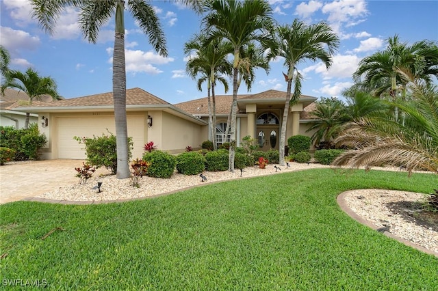 5131 SW 19th Ave, Cape Coral, FL 33914 - view of front of house featuring a garage, driveway, stucco siding, and a front lawn