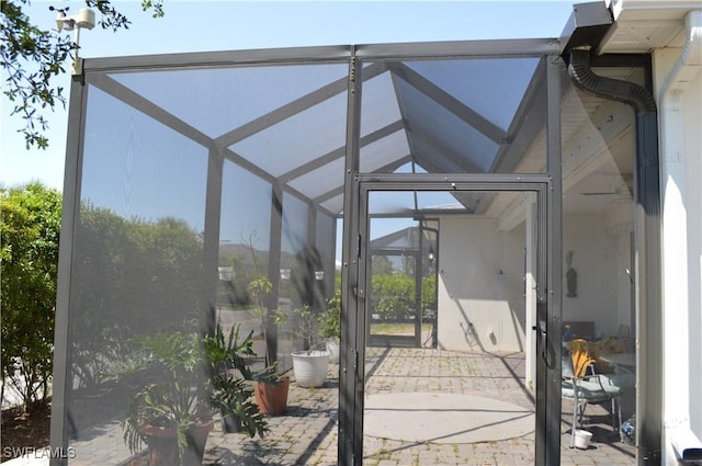 view of patio featuring glass enclosure