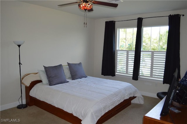 carpeted bedroom featuring visible vents, baseboards, ceiling fan, and multiple windows