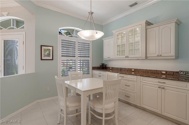 8815 Naples Heritage Dr Unit D9, Naples, FL 34112 - dining space featuring baseboards, ornamental molding, light tile patterned flooring, visible vents, and arched walkways