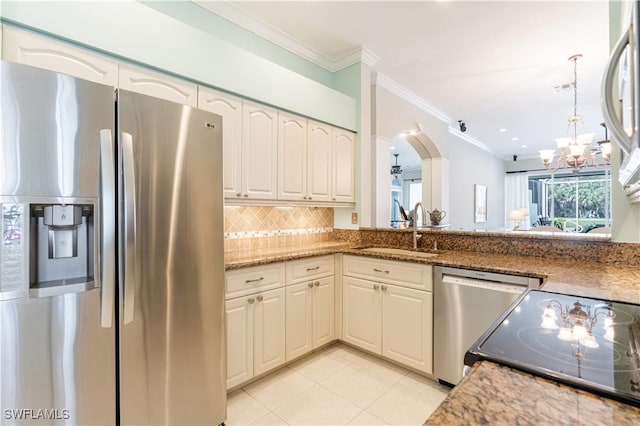 8815 Naples Heritage Dr Unit D9, Naples, FL 34112 - kitchen with a sink, ornamental molding, appliances with stainless steel finishes, a chandelier, and decorative backsplash