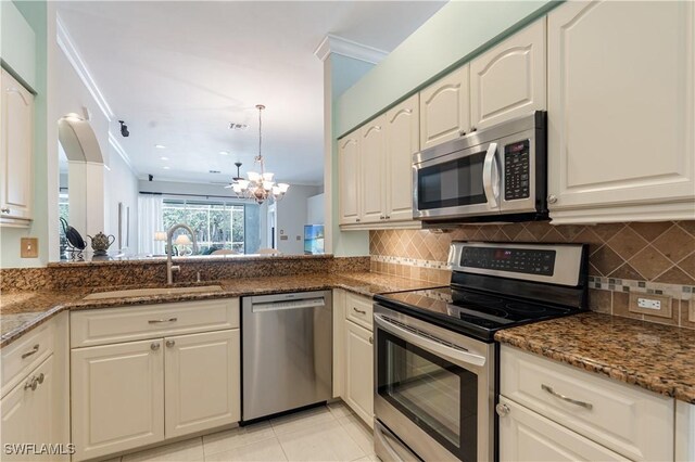 8815 Naples Heritage Dr Unit D9, Naples, FL 34112 - kitchen with a chandelier, dark stone countertops, appliances with stainless steel finishes, a sink, and decorative backsplash