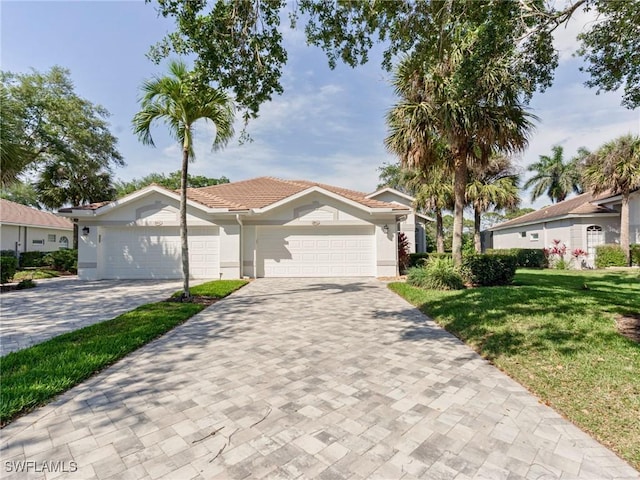 8815 Naples Heritage Dr Unit D9, Naples, FL 34112 - view of front of property featuring a front yard, an attached garage, a tile roof, stucco siding, and decorative driveway