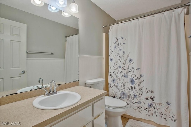 full bath featuring toilet, vanity, and a shower with shower curtain