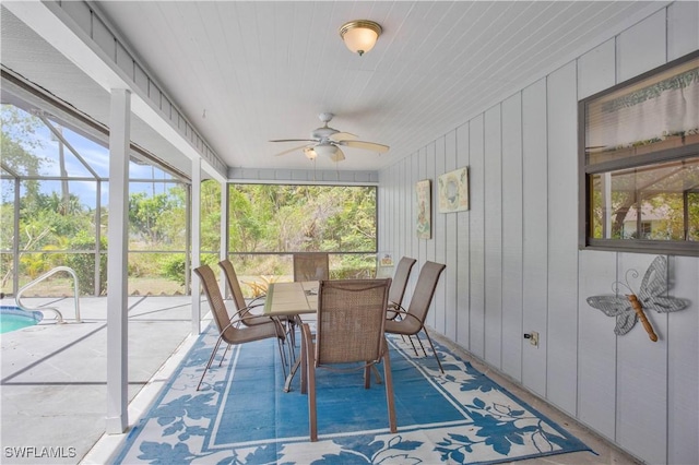 sunroom featuring a ceiling fan and outdoor dining area