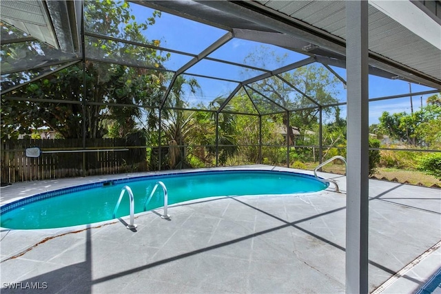 view of swimming pool featuring a patio area, fence, and a lanai