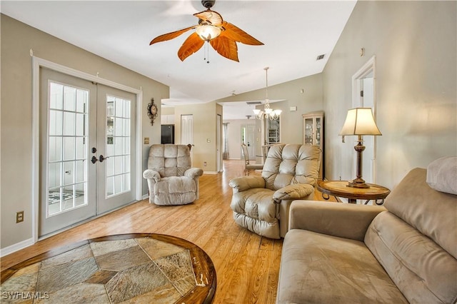 living area featuring french doors, wood finished floors, ceiling fan, vaulted ceiling, and a chandelier