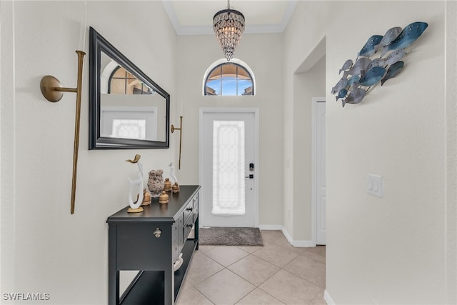 foyer with baseboards, ornamental molding, an inviting chandelier, and light tile patterned flooring