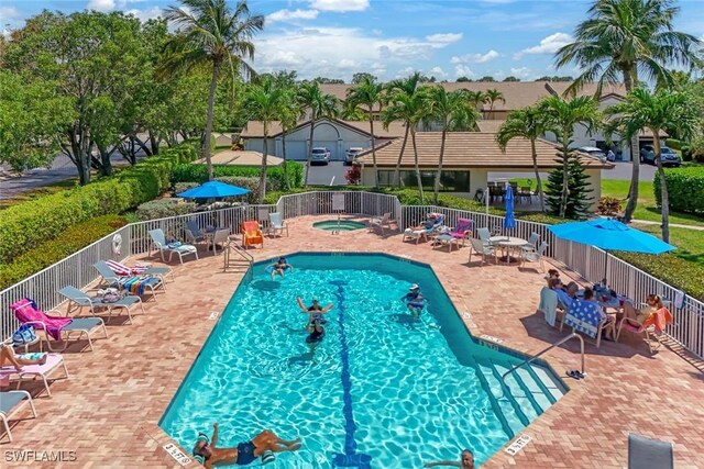 28750 Diamond Dr Unit 205, Bonita Springs, FL 34134 - community pool with fence, a hot tub, and a patio area