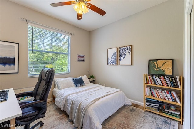 bedroom with wood finished floors, baseboards, a desk, and a ceiling fan