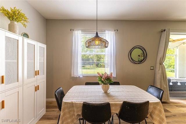 dining area with light wood-style flooring and baseboards