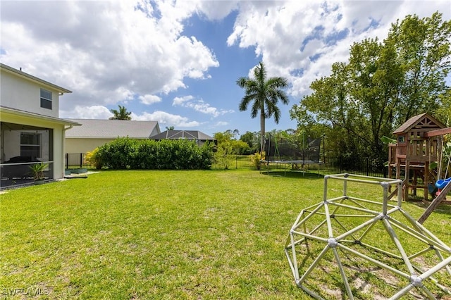 view of yard with a trampoline and a playground