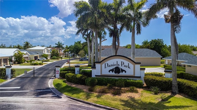 community / neighborhood sign featuring a gate and a residential view