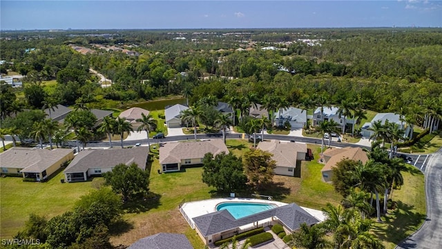 aerial view of residential area featuring a pool and a heavily wooded area