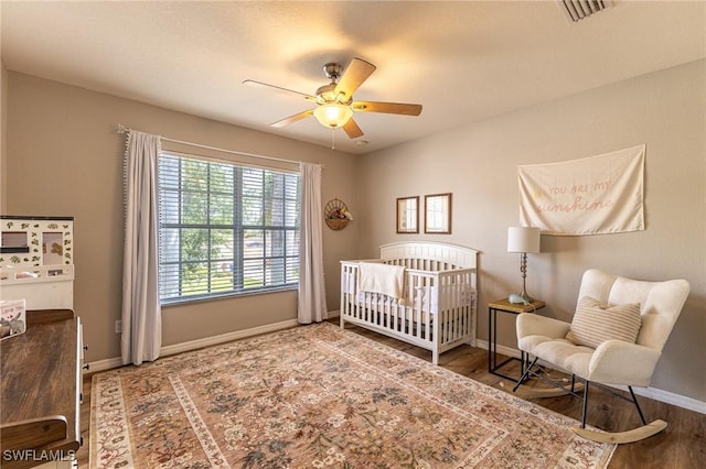 bedroom featuring baseboards, wood finished floors, and ceiling fan