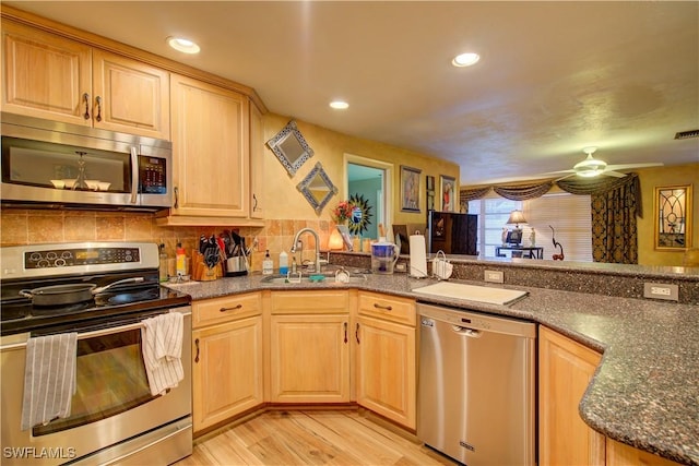 kitchen with light wood finished floors, light brown cabinets, a sink, and appliances with stainless steel finishes