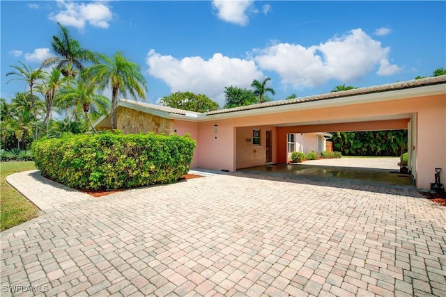 ranch-style house featuring stucco siding and decorative driveway