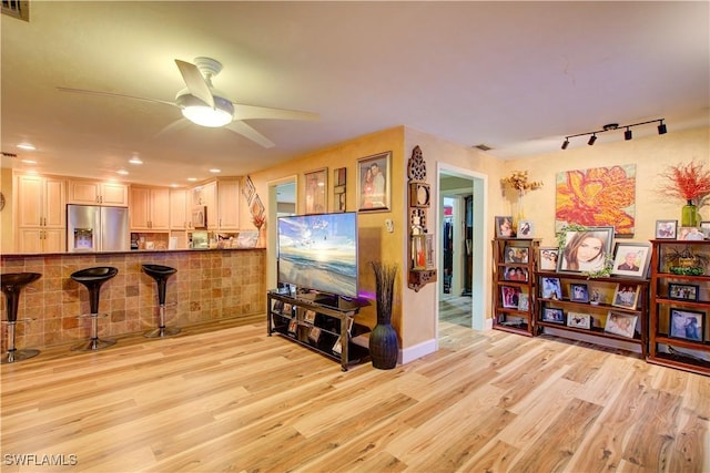 living room featuring light wood-type flooring, rail lighting, a ceiling fan, and recessed lighting