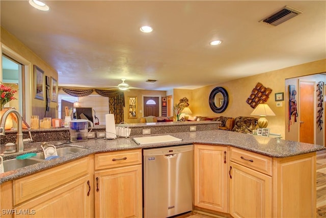 kitchen featuring light brown cabinets, dishwasher, a sink, and visible vents