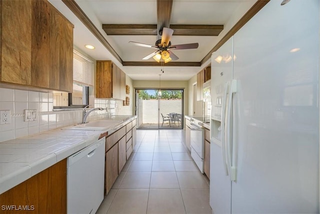 576 Retreat Dr Unit 101, Naples, FL 34110 - kitchen with a sink, white appliances, brown cabinets, decorative backsplash, and tile countertops