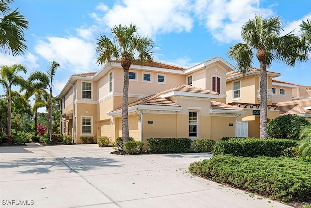 10637 Pelican Preserve Blvd Unit A, Fort Myers, FL 33913 - view of front of property with a tile roof, an attached garage, driveway, and stucco siding