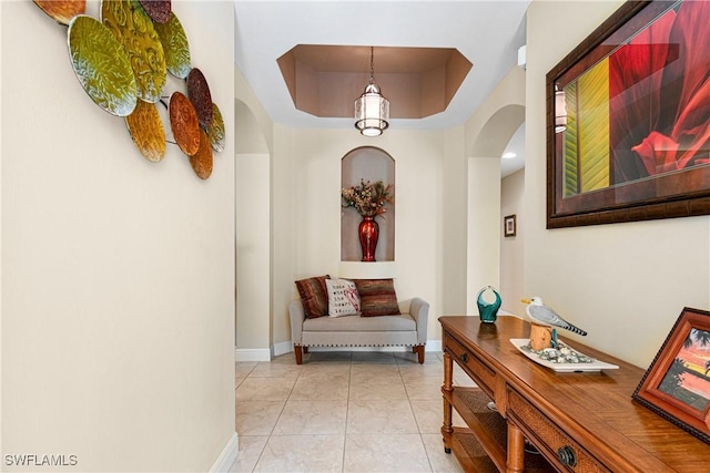 10637 Pelican Preserve Blvd Unit A, Fort Myers, FL 33913 - hallway with baseboards, arched walkways, a raised ceiling, and light tile patterned floors