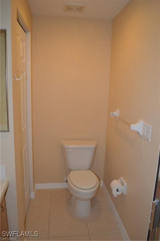 bathroom featuring vanity, tile patterned flooring, visible vents, toilet, and baseboards