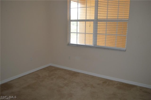 carpeted spare room featuring baseboards