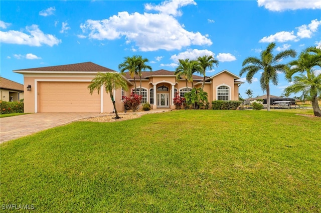 3428 SW 27th Pl, Cape Coral, FL 33914 - view of front of house featuring an attached garage, driveway, stucco siding, and a front yard