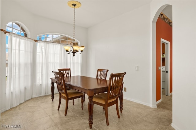 3428 SW 27th Pl, Cape Coral, FL 33914 - dining room featuring arched walkways, baseboards, an inviting chandelier, and washer / clothes dryer
