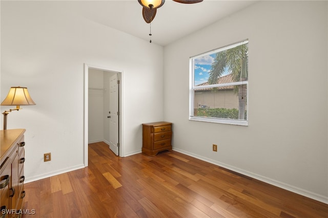3428 SW 27th Pl, Cape Coral, FL 33914 - unfurnished bedroom with a closet, baseboards, a walk in closet, and wood finished floors