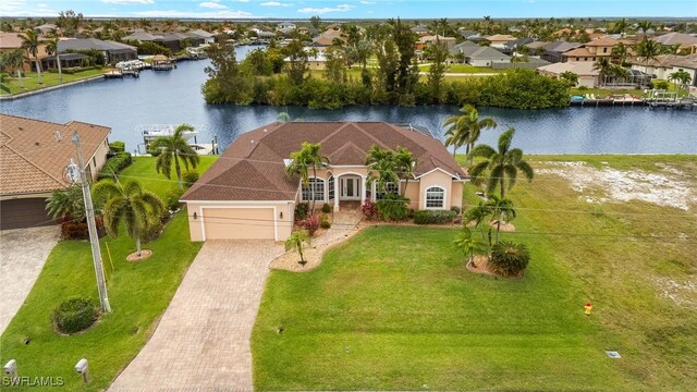 3428 SW 27th Pl, Cape Coral, FL 33914 - view of front of home with a water view, an attached garage, a residential view, and decorative driveway