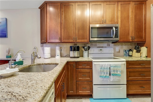 13199 Whitehaven Ln Unit 1808, Fort Myers, FL 33966 - kitchen with stainless steel microwave, a sink, brown cabinets, and white range with electric stovetop