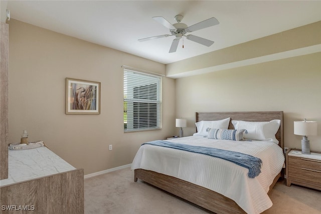 bedroom featuring ceiling fan, light colored carpet, and baseboards