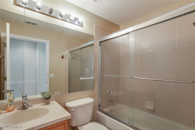 full bathroom featuring shower / bath combination with glass door, vanity, visible vents, and toilet