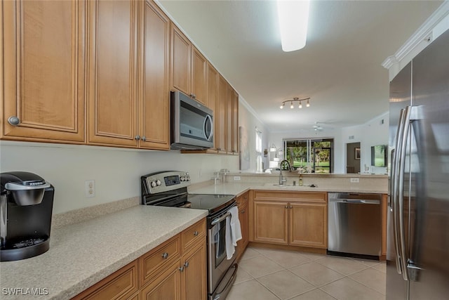 kitchen featuring appliances with stainless steel finishes, light tile patterned floors, a sink, and ornamental molding